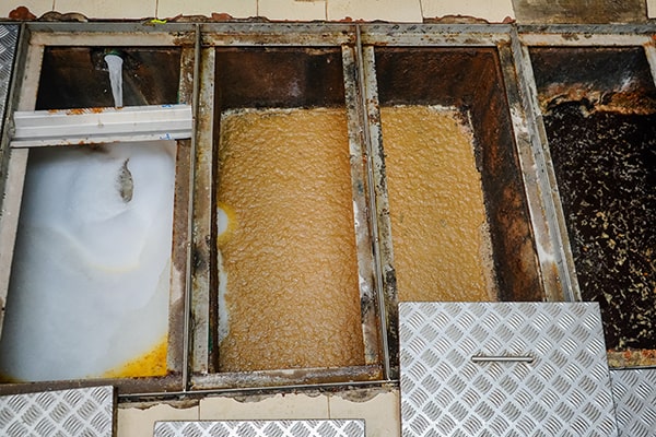 signs indicating a need for grease trap maintenance include slow draining sinks, foul odors, and grease buildup in drains